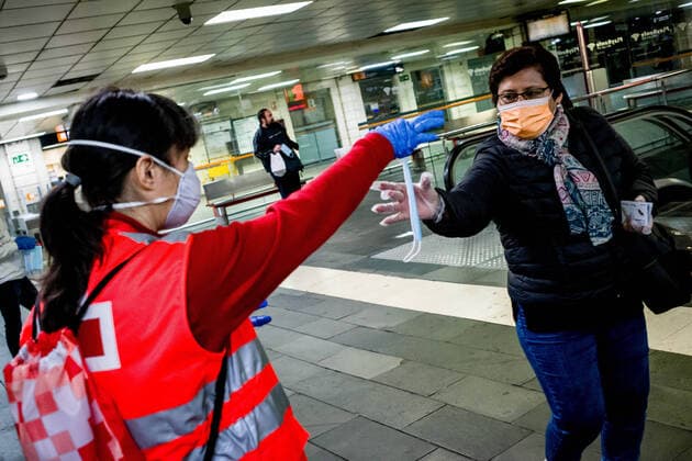 April 14, 2020, Barcelona, Catalonia, Spain: A Red Cross volunteer distributes protective face masks among commuters at Catalunya station in Barcelona. Thousands of people are returning to work after the Spanish government has lift the strictest measures of coronavirus confinement. Barcelona Spain - ZUMAb137 20200414_zap_b137_005 Copyright: xJordixBoixareux