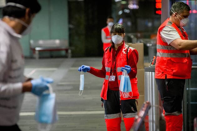 April 14, 2020, Barcelona, Catalonia, Spain: Red Cross volunteers hold protective face masks to distribute among commuters at Catalunya station in Barcelona. Thousands of people are returning to work after the Spanish government has lift the strictest measures of coronavirus confinement. Barcelona Spain - ZUMAb137 20200414_zap_b137_011 Copyright: xJordixBoixareux
