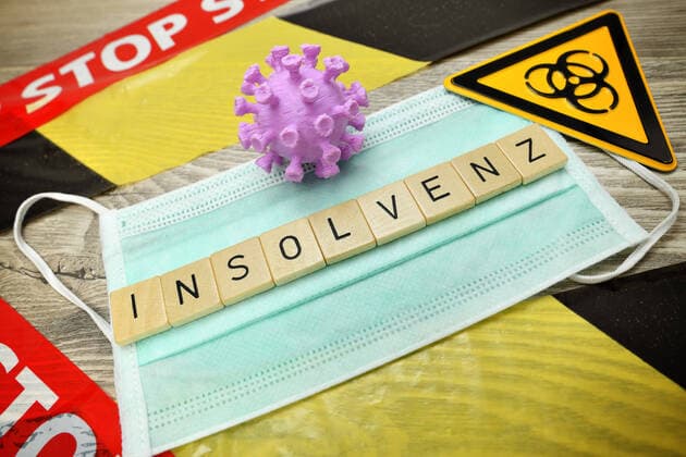 Spielbuchstaben bilden das Wort Insolvenz auf einer Schutzmaske, Coronavirus-Pandemie und Wirtschaftskrise