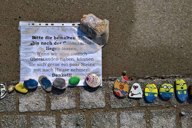 In Regensburg bemalen Kinder Kieselsteine und legen diese entlang der Donau bei Schwabelweis auf den Boden. Nach der Corona-Pandemie duerfen sich die Menschen bedienen und ihre Favoriten mit nach Hause nehmen. Foto: Bemalte Steine