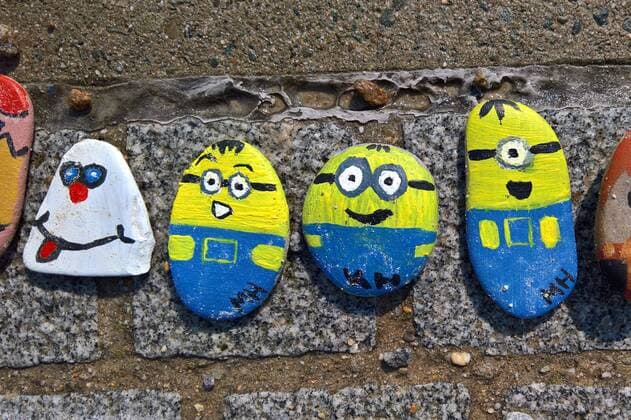 In Regensburg bemalen Kinder Kieselsteine und legen diese entlang der Donau bei Schwabelweis auf den Boden. Nach der Corona-Pandemie duerfen sich die Menschen bedienen und ihre Favoriten mit nach Hause nehmen. Foto: Bemalte Steine (Minions)