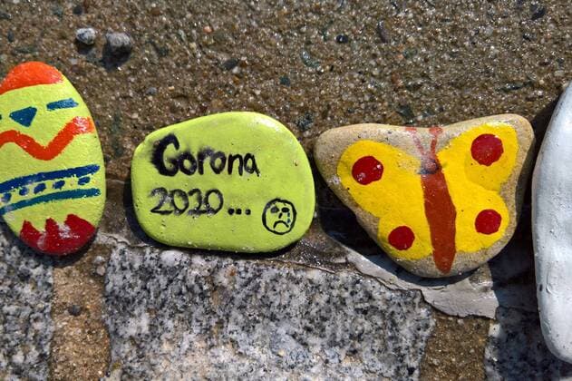 In Regensburg bemalen Kinder Kieselsteine und legen diese entlang der Donau bei Schwabelweis auf den Boden. Nach der Corona-Pandemie duerfen sich die Menschen bedienen und ihre Favoriten mit nach Hause nehmen. Foto: Bemalte Steine (Corona 2020, Schmetterling)