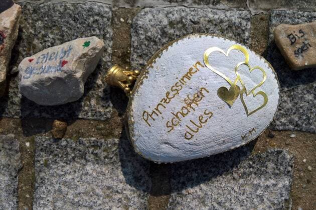In Regensburg bemalen Kinder Kieselsteine und legen diese entlang der Donau bei Schwabelweis auf den Boden. Nach der Corona-Pandemie duerfen sich die Menschen bedienen und ihre Favoriten mit nach Hause nehmen. Foto: Bemalte Steine (Bleibt gesund, Prinzessinnen schaffen alles - mit Krone)