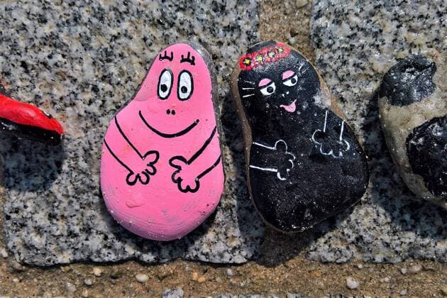 In Regensburg bemalen Kinder Kieselsteine und legen diese entlang der Donau bei Schwabelweis auf den Boden. Nach der Corona-Pandemie duerfen sich die Menschen bedienen und ihre Favoriten mit nach Hause nehmen. Foto: Bemalte Steine (Barbapappa bzw. Barbapapa und Barbamama)