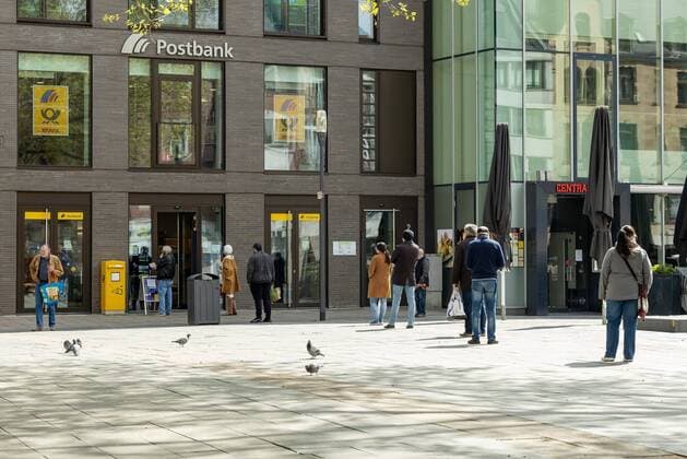 Wiesbaden, 14.04.2020, Wiesbaden, Shut down in Wiesbaden. Das Corona-Virus legt die Landeshauptstadt von Hessen lahm. Die Menschen stehen Schlange in großem Abstand an der Postbank Wiesbaden Hessen Deutschland