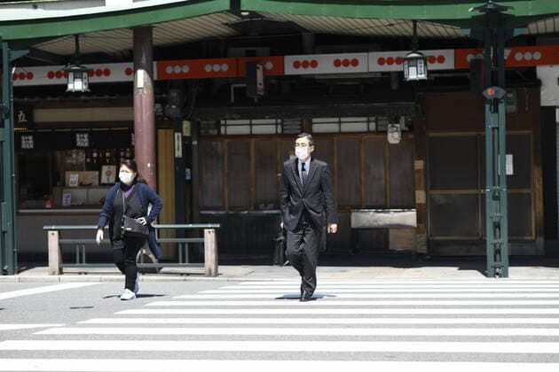 KYOTO, JAPAN - APRIL 14: Commuters wearing face mask walks cross the street in Kyoto on Tuesday, April 14, 2020, amid the spread of the new coronavirus. Japanese Prime Minister Shinzo Abe declared a state of emergency last week for Tokyo and six other prefectures including Kyoto to ramp up defenses against the spread of the coronavirus. (Photo: Richard Atrero de Guzman AFLO)  (125334783)