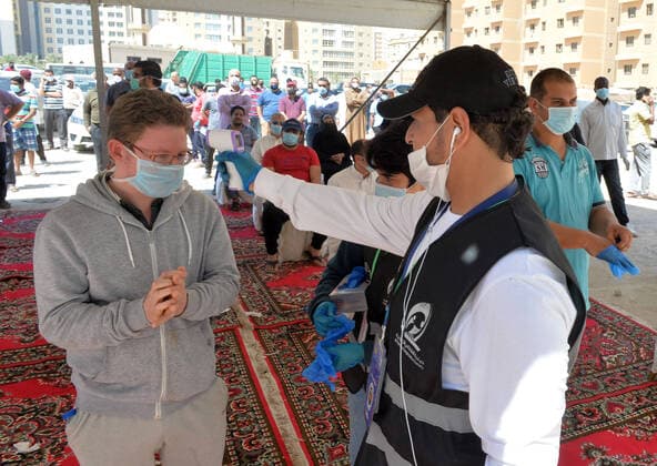(200414) -- AHMADI GOVERNORATE, April 14, 2020 (Xinhua) -- A worker checks temperature of a resident before he enters a new store for shopping in Mahboula area of Ahmadi Governorate, Kuwait, April 14, 2020. Kuwait opened on Tuesday a grocery store for residents of Mahboula area which is under lockdown due to the coronavirus. (Str Xinhua) KUWAIT-AHMADI GOVERNORATE-CORONAVIRUS-NEW STORE-OPENING 
