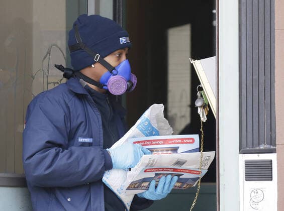 A postal worker wearing a protective face mask delivers the mail to an apartment building near where New York City Mayor Bill de Blasio visits The Campaign Against Hunger food pantry in New York City on Tuesday, April 14, 2020. As of today nearly 285,000 have been infected with Coronavirus and more than 14,000 people have died in NY, NJ and CT. There are signs however that the curve is flattening.  NYP20200414106 JOHNxANGELILLO