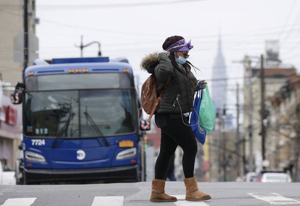A pedestrian wearing protective face mask crosses an intersection near Wyckoff Heights Medical Center in New York City on Tuesday, April 14, 2020. As of today nearly 285,000 have been infected with Coronavirus and more than 14,000 people have died in NY, NJ and CT. There are signs however that the curve is flattening.  NYP20200414120 JOHNxANGELILLO