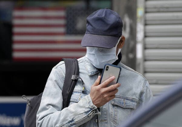 A pedestrian wearing protective face mask crosses an intersection near Wyckoff Heights Medical Center in New York City on Tuesday, April 14, 2020. As of today nearly 285,000 have been infected with Coronavirus and more than 14,000 people have died in NY, NJ and CT. There are signs however that the curve is flattening.  NYP20200414122 JOHNxANGELILLO