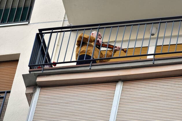 April 14, 2020, LÂ Hospitalet, Barcelona, Spain: A man plays a violin from his terrace applauding Covid-19 fighters during confinement..Citizens of LÂ Hospitalet at 8:00 pm continue to applaud showing gratitude to the people who are struggling in the fight against the Covid-19 health crisis, they give each other hope. LÂ Hospitalet Spain - ZUMAs197 20200414_zaa_s197_113 Copyright: xRamonxCostax