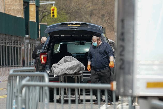 April 14, 2020, New York, NY, USA: A man loads a body into a hearse from a refrigeration trailer serving as a temporary morgue outside of Brooklyn Hospital Center in the Borough of Brooklyn on April 14, 2020 in New York. New York USA - ZUMAb148 20200414_zap_b148_027 Copyright: xBryanxSmithx