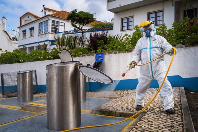 April 14, 2020, Ericeira, Portugal: An employee of the Ericeira parish council, equipped with the recommended protective materials, disinfects the recycling tanks with a solution based on hypochlorite (bleach)..The municipality of Mafra had 70 cases of COVID-19 pandemic. In order to prevent the spread of the virus, the Ericeira Parish Council perform weekly street disinfection. Ericeira Portugal - ZUMAs197 20200414_zaa_s197_171 Copyright: xHenriquexCasinhasx
