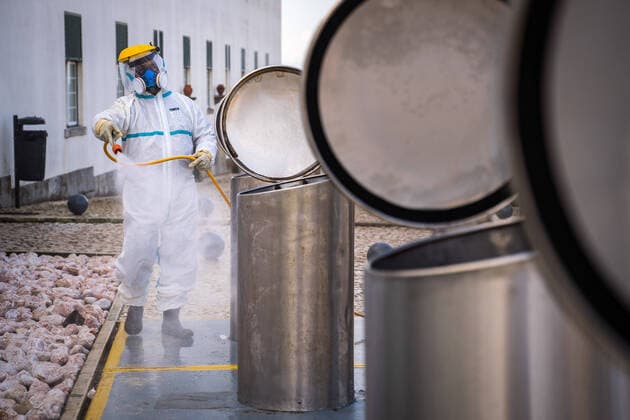 April 14, 2020, Ericeira, Portugal: An employee of the Ericeira parish council, equipped with the recommended protective materials, disinfects the recycling tanks with a solution based on hypochlorite (bleach)..The municipality of Mafra had 70 cases of COVID-19 pandemic. In order to prevent the spread of the virus, the Ericeira Parish Council perform weekly street disinfection. Ericeira Portugal - ZUMAs197 20200414_zaa_s197_172 Copyright: xHenriquexCasinhasx
