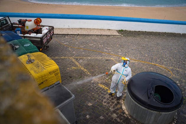 April 14, 2020, Ericeira, Portugal: An employee of the Ericeira parish council, equipped with the recommended protective materials, disinfects the recycling tanks with a solution based on hypochlorite (bleach)..The municipality of Mafra had 70 cases of COVID-19 pandemic. In order to prevent the spread of the virus, the Ericeira Parish Council perform weekly street disinfection. Ericeira Portugal - ZUMAs197 20200414_zaa_s197_182 Copyright: xHenriquexCasinhasx