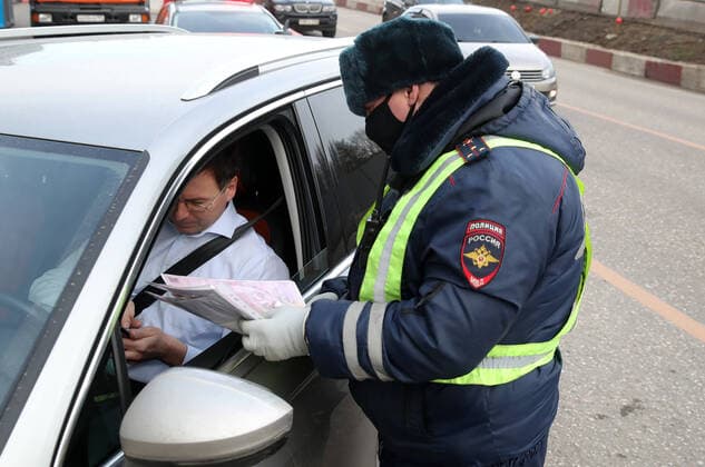 MOSCOW, RUSSIA - APRIL 15, 2020: A traffic police officer carries out an ID check during the pandemic of the novel coronavirus disease (COVID-19). Traffic police have set up checkpoints around the city to stop vehicles and see if drivers have permission to travel during the lockdown. On 13 April 2020, the Moscow government introduced a digital permit system aimed at further restricting movement. Under the new scheme, which becomes mandatory from 15 April, people need to apply for permits to travel on a vehicle or public transport around the city. Earlier, on 11 April, the Moscow government restricted vehicles registered outside Moscow Region from entering the Russian capital. Since 31 March 2020, Moscow has been on lockdown. As of 15 April 2020, Russia has reported more than 21,100 confirmed cases of the novel coronavirus infection, with  TS0D5C61