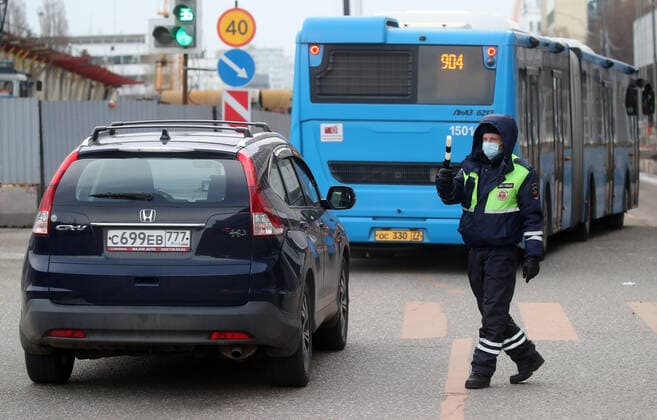 MOSCOW, RUSSIA - APRIL 15, 2020: A traffic police officer carries out ID checks on Volokolamskoye Shosse Motorway during the pandemic of the novel coronavirus disease (COVID-19). Traffic police have set up checkpoints around the city to stop vehicles and see if drivers have permission to travel during the lockdown. On 13 April 2020, the Moscow government introduced a digital permit system aimed at further restricting movement. Under the new scheme, which becomes mandatory from 15 April, people need to apply for permits to travel on a vehicle or public transport around the city. Earlier, on 11 April, the Moscow government restricted vehicles registered outside Moscow Region from entering the Russian capital. Since 31 March 2020, Moscow has been on lockdown. As of 15 April 2020, Russia has reported more than 21,100 confirmed cases of the no  TS0D5C66