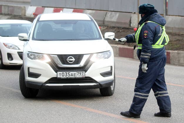 MOSCOW, RUSSIA - APRIL 15, 2020: A traffic police officer carries out ID checks on Volokolamskoye Shosse Motorway at the entrance to Moscow during the pandemic of the novel coronavirus disease (COVID-19). Traffic police have set up checkpoints around the city to stop vehicles and see if drivers have permission to travel during the lockdown. On 13 April 2020, the Moscow government introduced a digital permit system aimed at further restricting movement. Under the new scheme, which becomes mandatory from 15 April, people need to apply for permits to travel on a vehicle or public transport around the city. Earlier, on 11 April, the Moscow government restricted vehicles registered outside Moscow Region from entering the Russian capital. Since 30 March 2020, Moscow has been on lockdown. As of 15 April 2020, Russia has reported more than 21,100  TS0D5C69