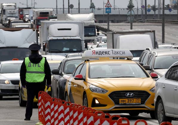 MOSCOW, RUSSIA - APRIL 15, 2020: A traffic police officer stands guard on Volokolamskoye Shosse Motorway during the pandemic of the novel coronavirus disease (COVID-19). Traffic police have set up checkpoints around the city to stop vehicles and see if drivers have permission to travel during the lockdown. On 13 April 2020, the Moscow government introduced a digital permit system aimed at further restricting movement. Under the new scheme, which becomes mandatory from 15 April, people need to apply for permits to travel on a vehicle or public transport around the city. Earlier, on 11 April, the Moscow government restricted vehicles registered outside Moscow Region from entering the Russian capital. Since 30 March 2020, Moscow has been on lockdown. As of 15 April 2020, Russia has reported more than 21,100 confirmed cases of the novel coron  TS0D5C9F