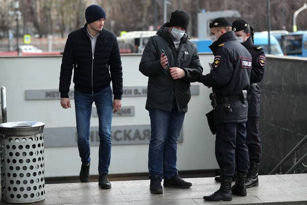 MOSCOW, RUSSIA - APRIL 15, 2020: A commuter in a face mask shows a digital code on his smartphone to police officers during an ID check at the entrance to Kiyevskaya Station of the Moscow Underground (metro) during the pandemic of the novel coronavirus disease (COVID-19). On 13 April 2020, the Moscow government introduced a digital permit system aimed at further restricting movement. Under the new scheme, which becomes mandatory from 15 April, people need to apply for permits to travel on public transport or a vehicle around the city. Since 30 March 2020, Moscow has been on lockdown. As of 15 April 2020, Russia has reported more than 21,100 confirmed cases of the novel coronavirus infection, with more than 13,000 confirmed cases in Moscow. Mikhail Tereshchenko TASS  TS0D5CCF