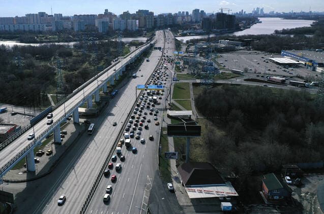 MOSCOW, RUSSIA - APRIL 15, 2020: An aerial view of a traffic congestion at a checkpoint on Leningradskoye Shosse Motorway at the entrance to Moscow during the pandemic of the novel coronavirus disease (COVID-19). Traffic police have set up checkpoints around the city to stop vehicles and see if drivers have permission to travel during the lockdown. On 13 April 2020, the Moscow government introduced a digital permit system aimed at further restricting movement. Under the new scheme, which becomes mandatory from 15 April, people need to apply for permits to travel on a vehicle or public transport around the city. Earlier, on 11 April, the Moscow government restricted vehicles registered outside Moscow Region from entering the Russian capital. Since 30 March 2020, Moscow has been on lockdown. As of 15 April 2020, Russia has reported more tha  TS0D5CE6