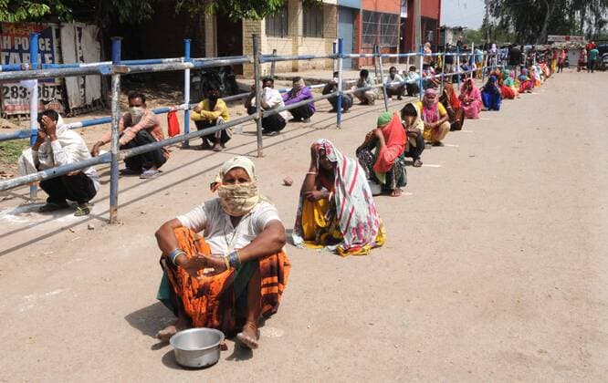 News Bilder des Tages CHANDIGARH, INDIA - APRIL 15: People queue for food during the lockdown at Colony No 4, Industrial Area Ph 1 on April 15, 2020 in Chandigarh, India. (Photo by Keshav Singh Hindustan Times) Government Provide Food To Homeless And Poor Amid Lockdown To Prevent Covid-19