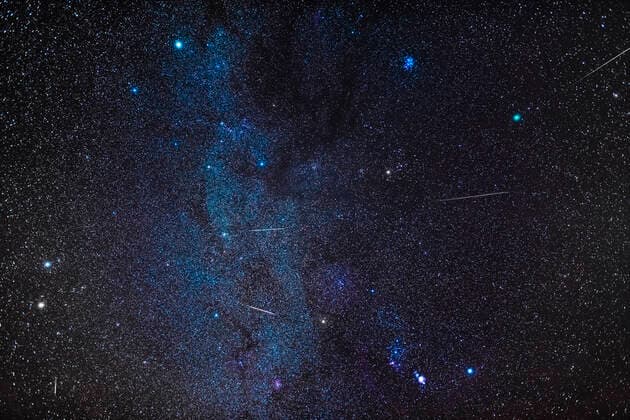 December 12, 2018 - A composite of several exposures to stack images of five Geminid meteors into a wide view of the winter sky with Comet Wirtanen at upper right in Taurus. The meteors are shooting away from the radiant point in Gemini near the bluish-white star Castor at left. The Milky Way runs vertically through the frame from Auriga at top to past Orion at bottom. Capella and the Pleiades are at top, Orion is at bottom, Taurus is at centre, while Gemini and the radiant point of the shower is at lower left. The Taurus Dark Clouds complex is at upper centre. Copyright: AlanxDyer StocktrekxImages ADY200617S