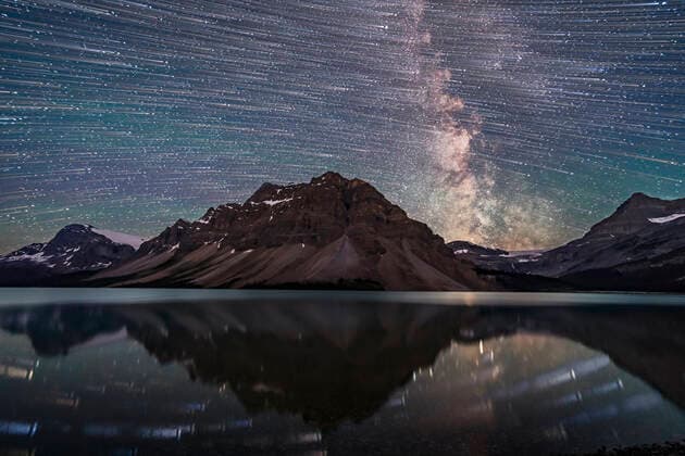 IMAGO Creative: Reflexionen - Natur A blend of images to show the stars of the southern sky moving from east to west (left to right) over the Rocky Mountains at Bow Lake, in Banff, Alberta, Canada. The main peak at centre is Bow Peak. Crowfoot Glacier is at far left; Bow Glacier is at right below the Milky Way. A single static image shows the Milky Way and stars at the end of the motion sequence. The star trails and Milky Way reflect in the calm waters of Bow Lake this night on July 16, 2018, though they appear large and out of focus. Copyright: AlanxDyer StocktrekxImages ADY200699S