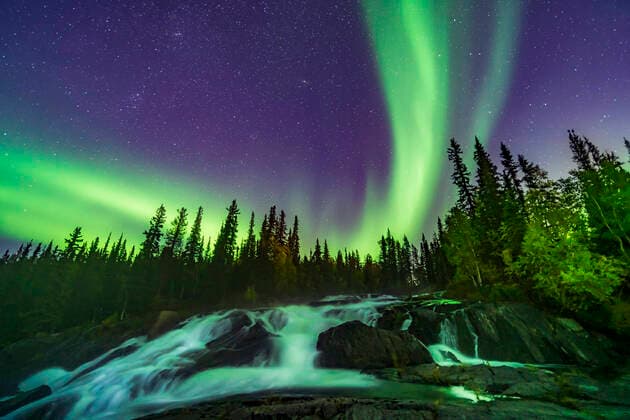 September 8, 2019 - The northern lights over the waterfalls known as the Ramparts on the Cameron River east of Yellowknife, Northwest Territories, Canada. The aspen trees are turning yellow on this September evening. This is looking northeast toward Perseus and Andromeda. M31 is at top centre. Copyright: AlanxDyer StocktrekxImages ADY200765S