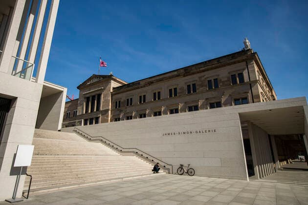 Einsamer Mensch auf der Treppen der geschlossenen James-Simon-Galerie in Berlin am 16. April 2020. Die von Bund und Laender um die Verbreitung des Coronavirus (SARS-CoV-2) zu verlangsamen beschlossenenen Massnahmen dauern auch vor der Ostertage weiter an. Die Debatte ueber eine Mundschutzpflicht und die Wirksamkeit der Masken dauert in der Oeffentlichkeit weiter an. Coronavirus in Berlin