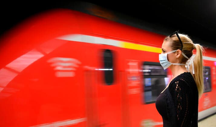 Frau mit Mundschutzmaske, wartet auf Zug, S-Bahn, Corona-Krise, Stuttgart, Baden-Württemberg, Deutschland Coronavirus