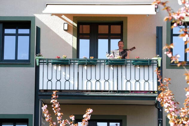 Jeden Abend geben Maria Petrowa (Querflöte, Chorsängerin an der Oper Halle) und Ulrich Duelli (Gitarre, Physiotherapeut) auf ihren Balkons in einem Wohnhaus am Landrain ein ca. 15minüges Konzert für die Hausbewohner und Nachbarn und vor allem für die dort lebenden Senioren, die sich während der Coronakrise in Selbstquarantäne befinden. Halle (Saale), 17.04.2020