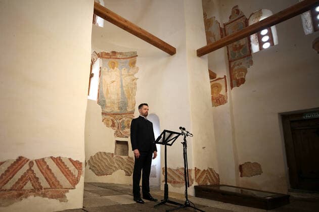 LENINGRAD REGION, RUSSIA - APRIL 19, 2020: Mariinsky Theatre soloist, operatic baritone singer Vladimir Tselebrovsky, gives an online Easter concert at St George s Church of the ancient Ladoga fortress at the Staraya Ladoga Museum Reserve on the Volkhov River near Lake Ladoga. Patriarch Kirill of Moscow and All Russia urged believers to celebrate Easter at home and watch liturgies broadcasted on TV amid the ongoing COVID-19 coronavirus pandemic. Peter Kovalev TASS  TS0D65DB