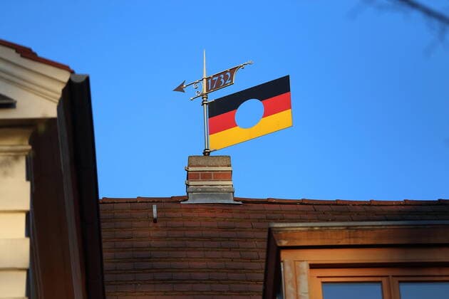 Eine Deutschlandfahne mit Loch, das Logo der Bundesstiftung zur Aufarbeitung der SED-Diktatur, dient als Wetterfahne auf einem Hausdach in Potsdam, 18. April 2020. Wetterfahne
