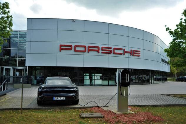 Firmenareal vom Porsche Zentrum in Regensburg. Am Parkplatz steht ein Taycan (E Mobilitaet) an einer Strom-Ladesaeule. Der Sportwagenbauer Porsche AG wird seine Werke in der kommenden Woche noch nicht wieder anlaufen lassen. Die Produktion im Stammwerk Stuttgart - Zuffenhausen und Leipzig bleibe eine weitere Woche ausgesetzt, sagte ein Sprecher am Donnerstag (16.04.2020). Es gibt weiterhin Engpaesse bei globalen Lieferketten, die einen geordneten Wiederanlauf nicht zulassen