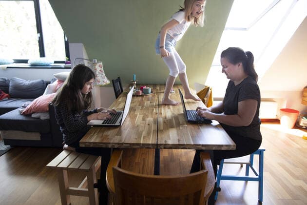 Thema: Homeoffice. Kind geht ueber Tische und Baenke Bonn Deutschland