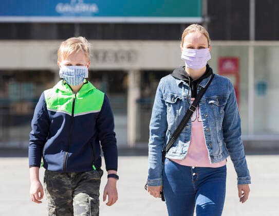 Deutschland, , , 20.04.2020, Presse, COVID-19 Deutschland faehrt langsam wieder hoch Bild: In Hessen haben die Geschaefte wieder geoeffnet, in Bayern nicht. Das wirkt sich vor allem auf die Osthessische Stadt Fulda aus, die nicht weit von der Bayerischen Landesgrenze entfernt liegt. Eine Frau und ein Kind laufen mit Mundschutz durch Fulda. Im Hintergrund ist die Karstadt Filliale, die allerdings noch geschlossen bleiben muss. Copyright: HMBxMedia OliverxMueller
