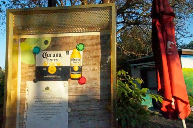 Ein Bremer Gartenlokal, das wegen der Corona-Krise schließen musste, hat in seinem Schaukasten Werbung für Corona-Bier ausgehängt.