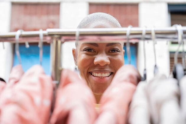 Portrait of happy woman behind clothes rail model released Symbolfoto AFVF05917
