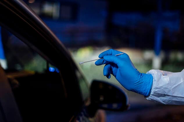 Doctor wearing protective clothing, doing viral swab test model released Symbolfoto CJMF00291