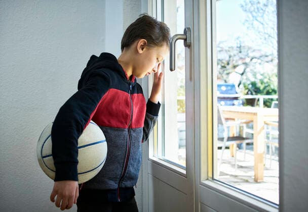 IMAGO Creative: Lokalhelden - Jugendsportbildung Sad boy with basketball leaning against the window model released Symbolfoto property released DIKF00406