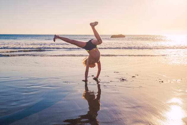 Little boy practicing handstand on the beach model released Symbolfoto IHF00320