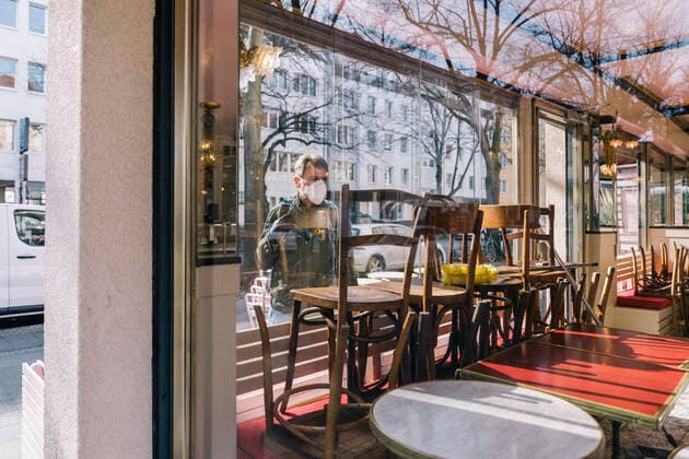 Man with mask looking through window into closed restaurant model released Symbolfoto MFF05144