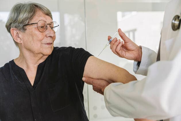 Doctor injecting vaccine into senior patient™s arm model released Symbolfoto property released MFF05450