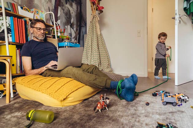 Son tying his father working on laptop in children s room model released Symbolfoto property released MFF05575