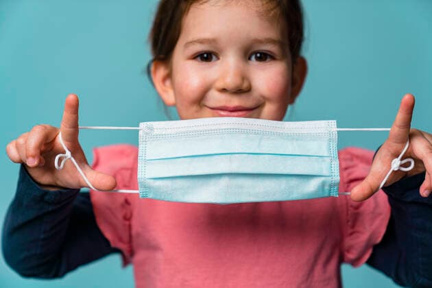 Portrait of smiling girl putting on a mask model released Symbolfoto property released MGIF00889