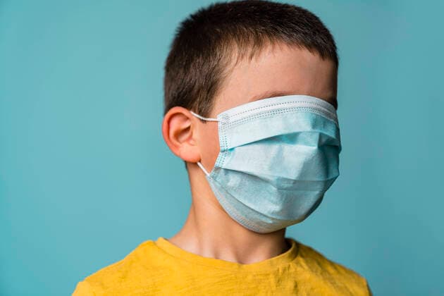 Portrait of boy covering his face with mask model released Symbolfoto property released MGIF00893