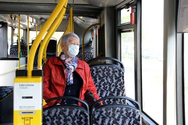 Ab Montag ist in Berlin in den Bussen und Bahnen der BVG und auch der S-Bahn das Tragen von Schutzmasken Pflicht -ältere Frau (model released) mit Schutzmaske unterwegs mit dem Bus