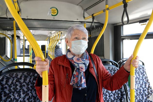 Ab Montag ist in Berlin in den Bussen und Bahnen der BVG und auch der S-Bahn das Tragen von Schutzmasken Pflicht -ältere Frau (model released) mit Schutzmaske unterwegs mit dem Bus
