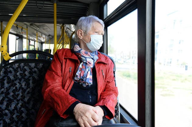 Ab Montag ist in Berlin in den Bussen und Bahnen der BVG und auch der S-Bahn das Tragen von Schutzmasken Pflicht -ältere Frau (model released) mit Schutzmaske unterwegs mit dem Bus